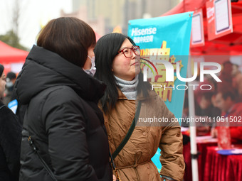 Job seekers are looking for suitable positions at a job fair for women in Fuyang, China, on March 6, 2024. (