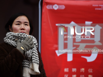 Job seekers are looking for suitable positions at a job fair for women in Fuyang, China, on March 6, 2024. (