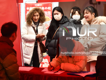 Job seekers are looking for suitable positions at a job fair for women in Fuyang, China, on March 6, 2024. (