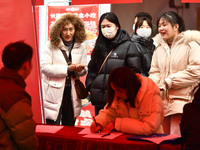 Job seekers are looking for suitable positions at a job fair for women in Fuyang, China, on March 6, 2024. (