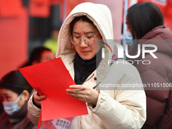 Job seekers are looking for suitable positions at a job fair for women in Fuyang, China, on March 6, 2024. (