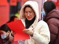 Job seekers are looking for suitable positions at a job fair for women in Fuyang, China, on March 6, 2024. (