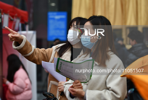 Job seekers are looking for suitable positions at a job fair for women in Fuyang, China, on March 6, 2024. 