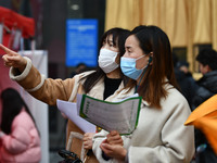 Job seekers are looking for suitable positions at a job fair for women in Fuyang, China, on March 6, 2024. (