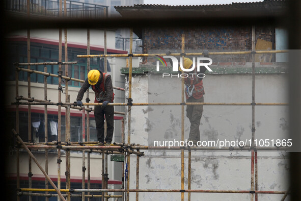 Construction workers are working at the renovation site of an old residential area in Wenhua Yi Village, Jiulongpo district, in Chongqing, C...