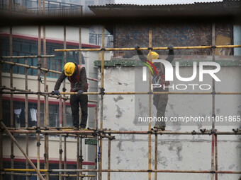 Construction workers are working at the renovation site of an old residential area in Wenhua Yi Village, Jiulongpo district, in Chongqing, C...