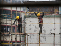 Construction workers are working at the renovation site of an old residential area in Wenhua Yi Village, Jiulongpo district, in Chongqing, C...