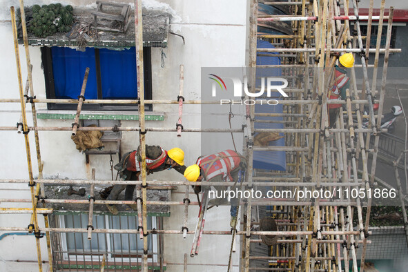 Construction workers are working at the renovation site of an old residential area in Wenhua Yi Village, Jiulongpo district, in Chongqing, C...