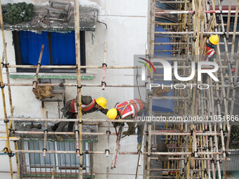 Construction workers are working at the renovation site of an old residential area in Wenhua Yi Village, Jiulongpo district, in Chongqing, C...