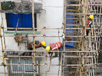 Construction workers are working at the renovation site of an old residential area in Wenhua Yi Village, Jiulongpo district, in Chongqing, C...