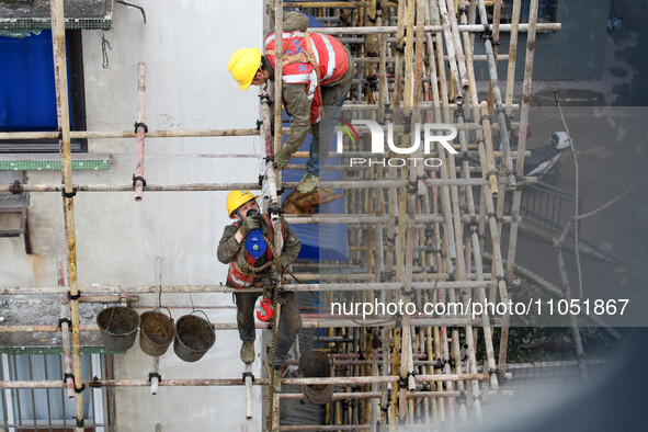 Construction workers are working at the renovation site of an old residential area in Wenhua Yi Village, Jiulongpo district, in Chongqing, C...