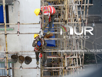 Construction workers are working at the renovation site of an old residential area in Wenhua Yi Village, Jiulongpo district, in Chongqing, C...