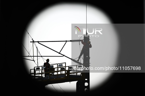 An overhead contact line worker from the Nanchang power supply section of Southern Railway is overhauling overhead contact line equipment in...