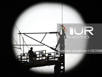 An overhead contact line worker from the Nanchang power supply section of Southern Railway is overhauling overhead contact line equipment in...