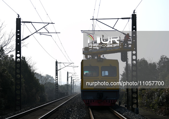 An overhead contact line worker from the Nanchang power supply section of Southern Railway is overhauling overhead contact line equipment in...