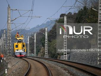 An overhead contact line worker from the Nanchang power supply section of Southern Railway is overhauling overhead contact line equipment in...