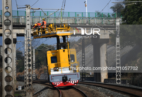 An overhead contact line worker from the Nanchang power supply section of Southern Railway is overhauling overhead contact line equipment in...