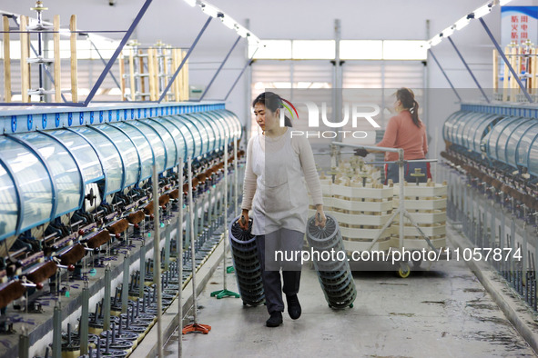 A female worker is working at a production workshop of a silk company in Chongqing, China, on March 8, 2024. 