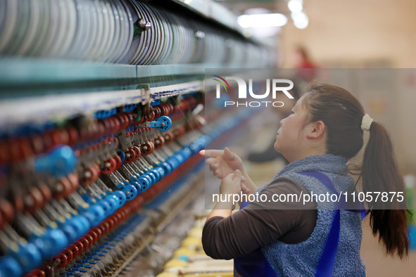 A female worker is working at a production workshop of a silk company in Chongqing, China, on March 8, 2024. 