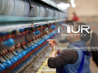 A female worker is working at a production workshop of a silk company in Chongqing, China, on March 8, 2024. (