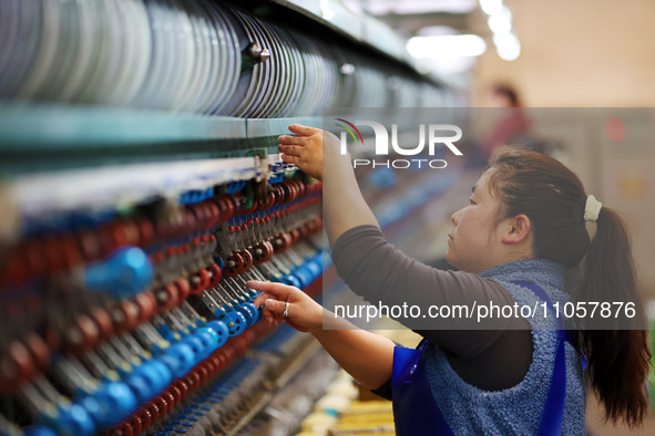 A female worker is working at a production workshop of a silk company in Chongqing, China, on March 8, 2024. 