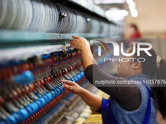 A female worker is working at a production workshop of a silk company in Chongqing, China, on March 8, 2024. (