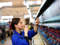 A female worker is working at a production workshop of a silk company in Chongqing, China, on March 8, 2024. (