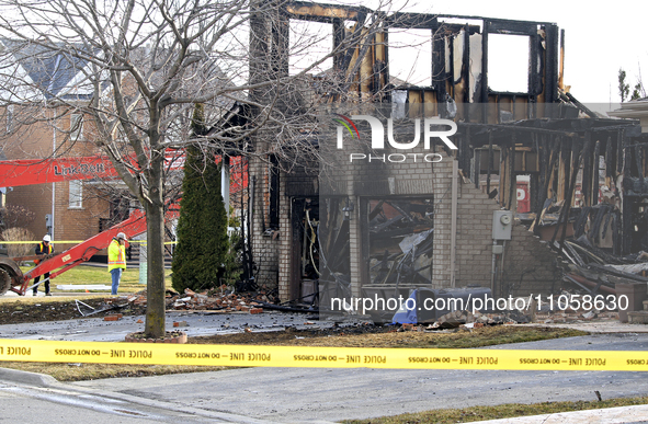 Demolition crews are waiting on the street in front of a home that was destroyed by a reported explosion and fire in Brampton, Ontario, Cana...