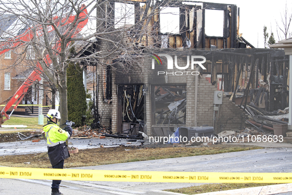 A fire official is photographing a home being torn down after it was destroyed by a reported explosion and fire in Brampton, Ontario, Canada...