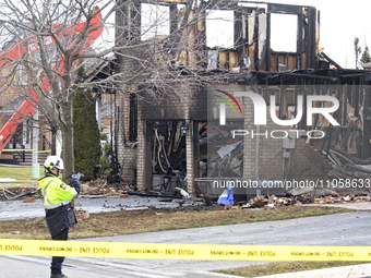 A fire official is photographing a home being torn down after it was destroyed by a reported explosion and fire in Brampton, Ontario, Canada...