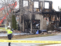 A fire official is photographing a home being torn down after it was destroyed by a reported explosion and fire in Brampton, Ontario, Canada...