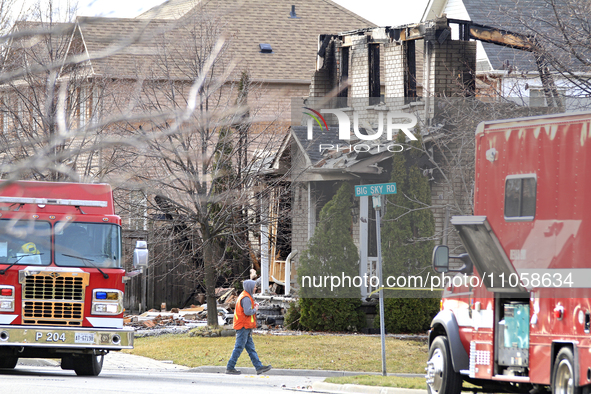 A demolition crew member is walking in front of a home that is being torn down after it was destroyed by a reported explosion and fire in Br...