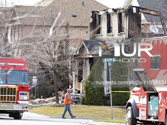 A demolition crew member is walking in front of a home that is being torn down after it was destroyed by a reported explosion and fire in Br...