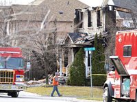 A demolition crew member is walking in front of a home that is being torn down after it was destroyed by a reported explosion and fire in Br...