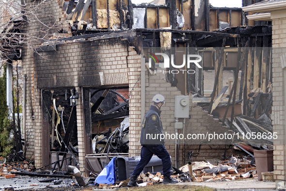 A fire investigator is walking past a home that is being torn down after it was destroyed by a reported explosion and fire in Brampton, Onta...