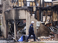 A fire investigator is walking past a home that is being torn down after it was destroyed by a reported explosion and fire in Brampton, Onta...