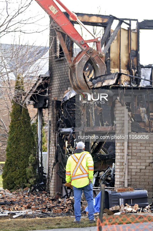 A demolition crew member is watching as a home is being torn down following its destruction by a reported explosion and fire in Brampton, On...