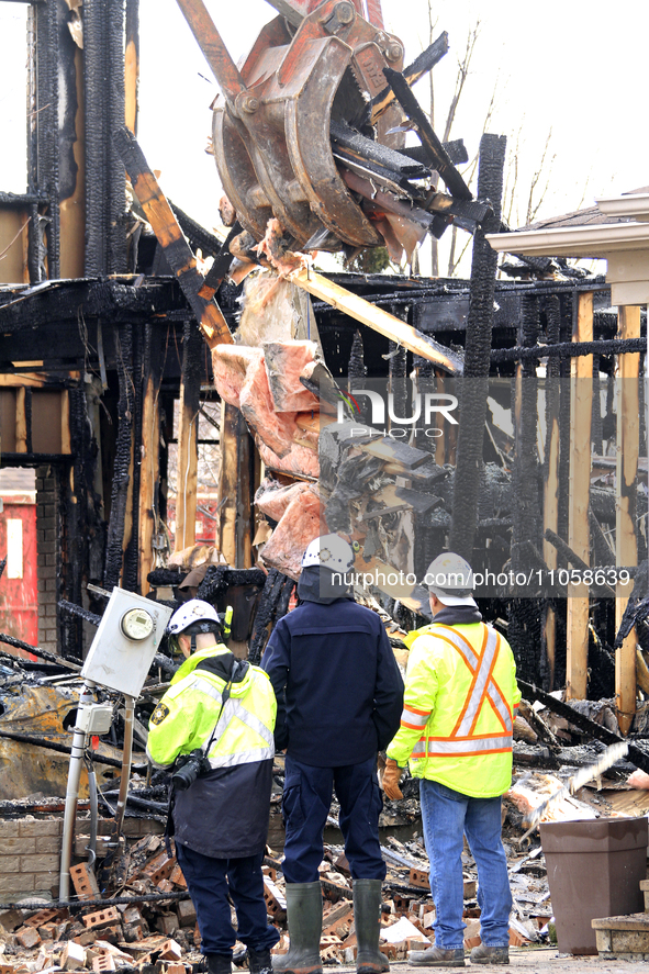 Demolition crews and fire officials are watching as a home is being torn down after it was destroyed by a reported explosion and fire in Bra...