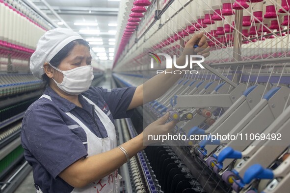 A worker is operating an intelligent production line at a textile company in Taizhou, Jiangsu Province, China, on March 12, 2024. 