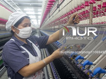 A worker is operating an intelligent production line at a textile company in Taizhou, Jiangsu Province, China, on March 12, 2024. (