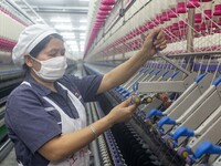 A worker is operating an intelligent production line at a textile company in Taizhou, Jiangsu Province, China, on March 12, 2024. (