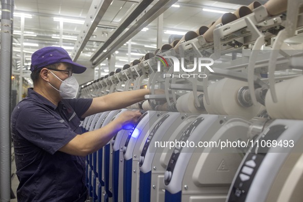 A worker is operating an intelligent production line at a textile company in Taizhou, Jiangsu Province, China, on March 12, 2024. 