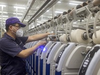 A worker is operating an intelligent production line at a textile company in Taizhou, Jiangsu Province, China, on March 12, 2024. (