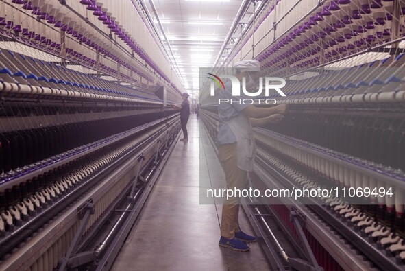 A worker is operating an intelligent production line at a textile company in Taizhou, Jiangsu Province, China, on March 12, 2024. 