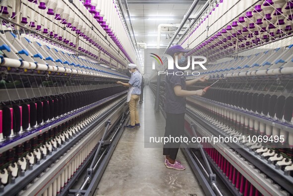 A worker is operating an intelligent production line at a textile company in Taizhou, Jiangsu Province, China, on March 12, 2024. 