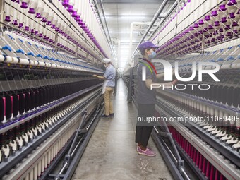 A worker is operating an intelligent production line at a textile company in Taizhou, Jiangsu Province, China, on March 12, 2024. (