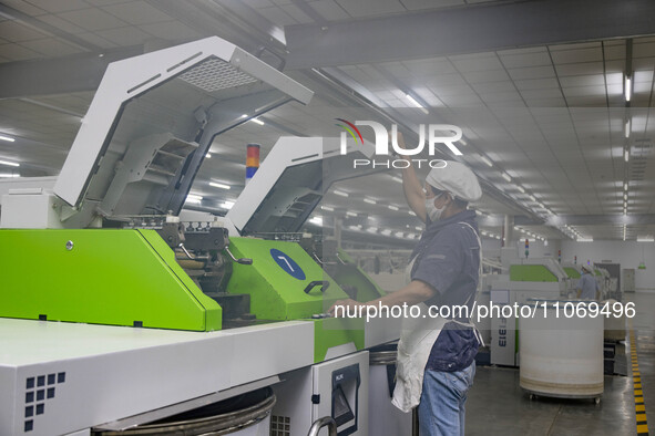 A worker is operating an intelligent production line at a textile company in Taizhou, Jiangsu Province, China, on March 12, 2024. 