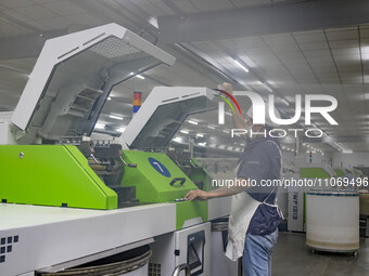 A worker is operating an intelligent production line at a textile company in Taizhou, Jiangsu Province, China, on March 12, 2024. (