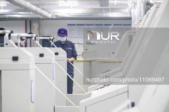 A worker is operating an intelligent production line at a textile company in Taizhou, Jiangsu Province, China, on March 12, 2024. 