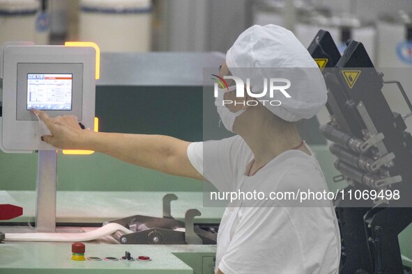 A worker is operating an intelligent production line at a textile company in Taizhou, Jiangsu Province, China, on March 12, 2024. 